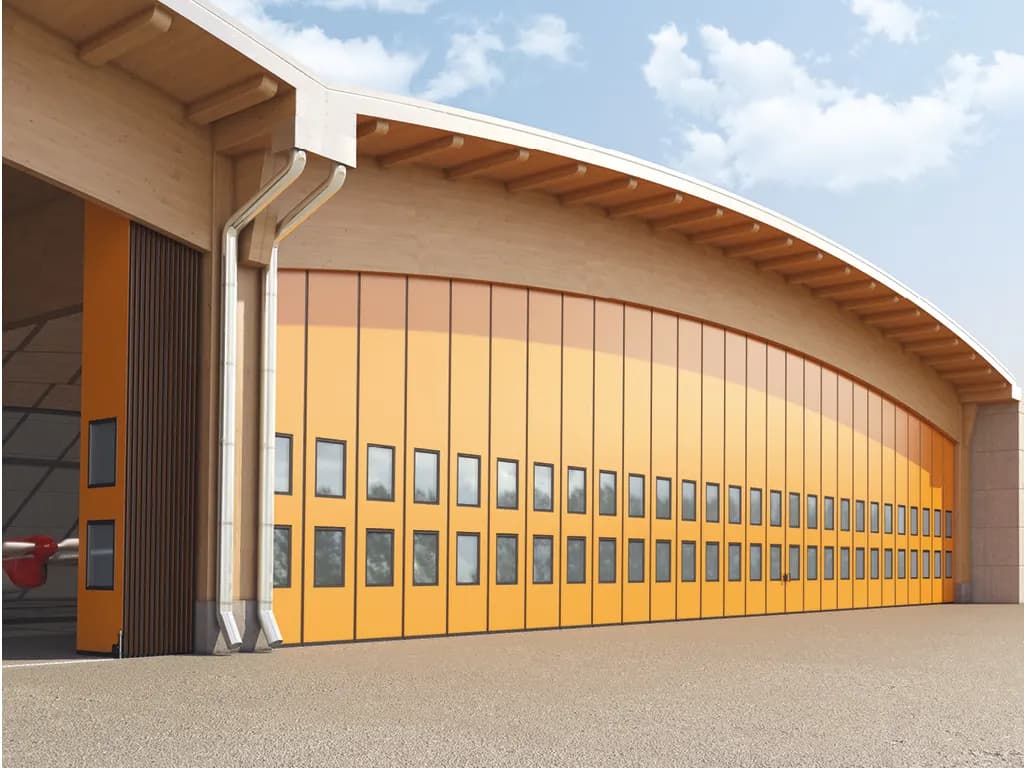 Variante de très grande largeur : porte pliante vitrée à nombreux panneaux fermant toute la façade d’une halle