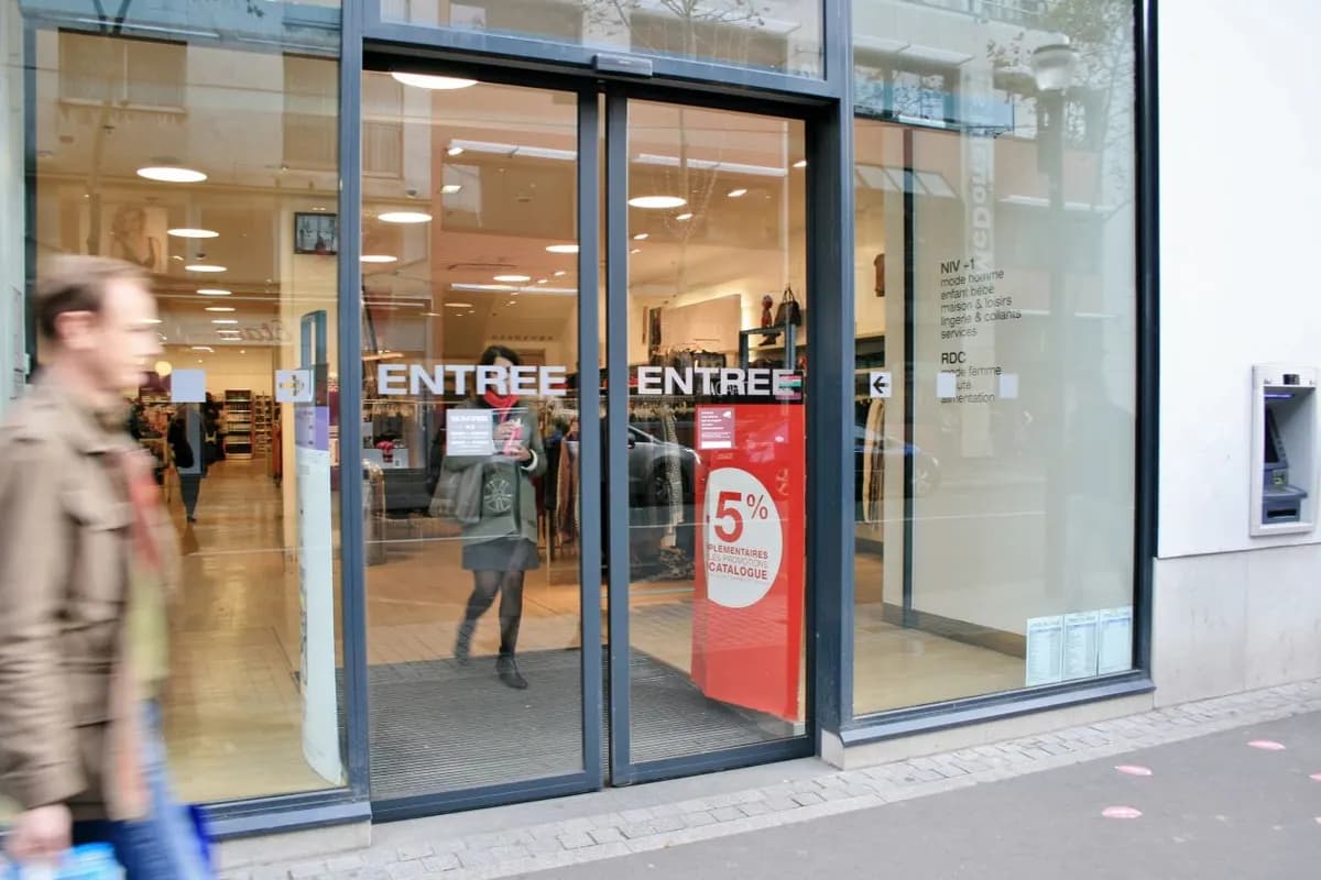 Vitrine de commerce à châssis aluminium anthracite avec porte automatique coulissante marquée « Entrée »