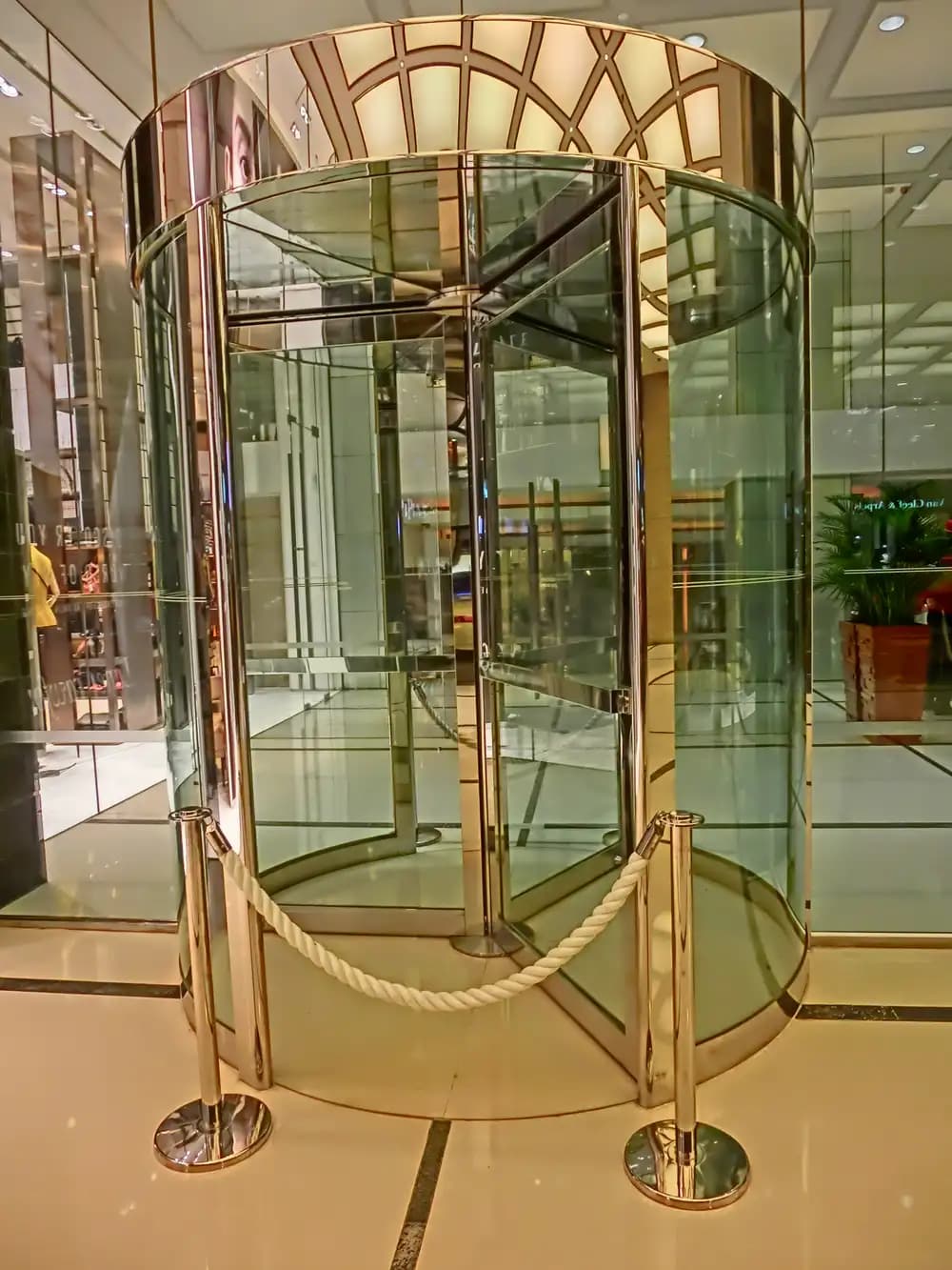 Variante de finition : porte tambour à cadre laiton poli dans le lobby d’un hôtel